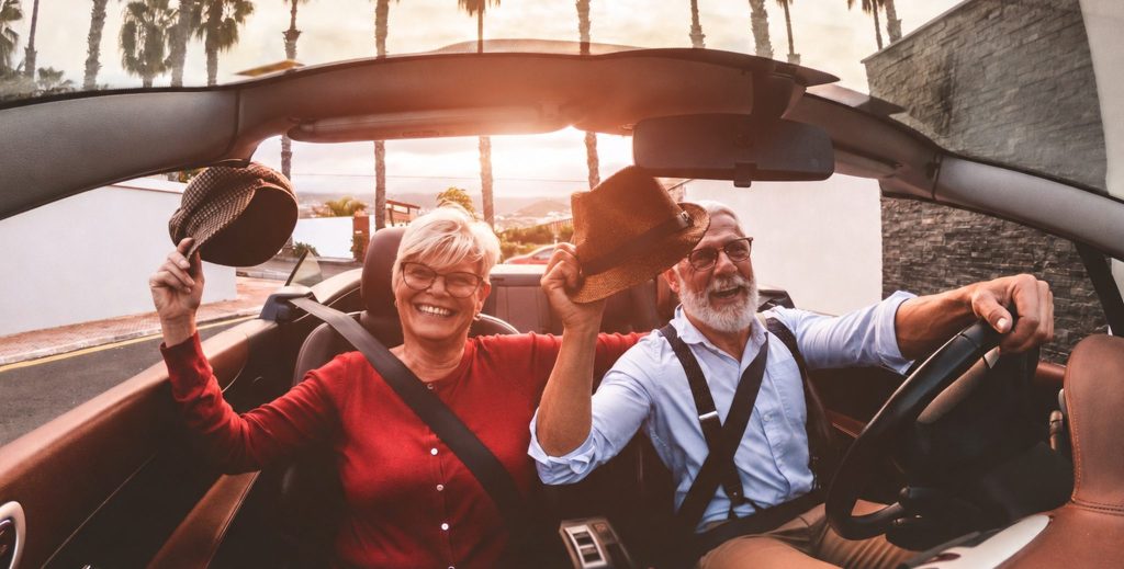 Retired couple enjoying a road trip in a convertible